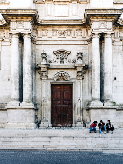 People sat on the concrete buildings during the day
